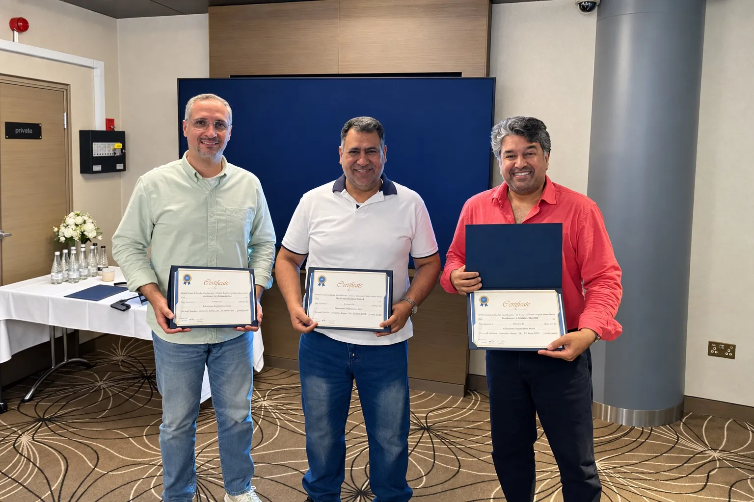 Three delegates holding their ARUK certificates of attendance